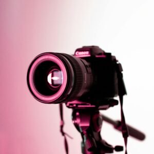 Canon DSLR camera with lens on tripod in studio lighting, perfect for photography enthusiasts.
