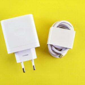 White SuperVOOC charger and cable on a bright yellow background, showcasing minimalist design.