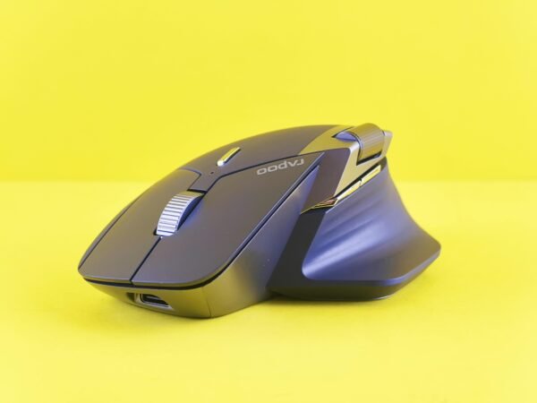 Modern ergonomic wireless mouse displayed on a vibrant yellow backdrop, showcasing sleek design.