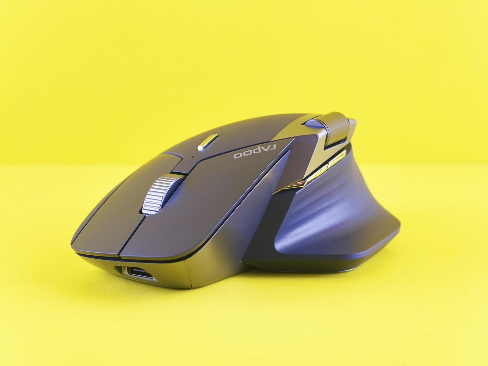 Modern ergonomic wireless mouse displayed on a vibrant yellow backdrop, showcasing sleek design.